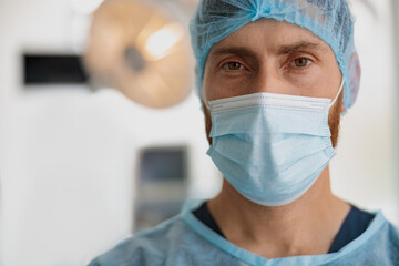 Fototapeta na wymiar Close up of professional doctor in mask standing in operating room before surgery