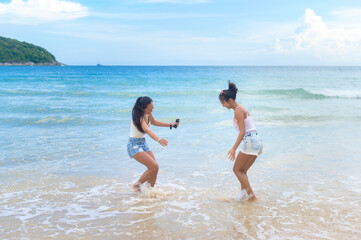 Naklejka premium Two attractive women friends enjoying and relaxing on the beach, Summer, vacation, holidays, Lifestyles concept.