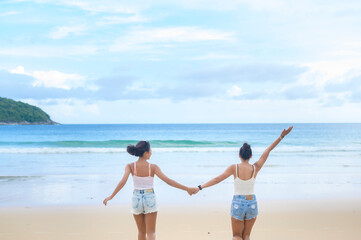 Two attractive women friends enjoying and relaxing on the beach,  Summer, vacation, holidays, Lifestyles concept.