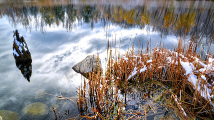 First snow fall on the lake of the public park in winter.