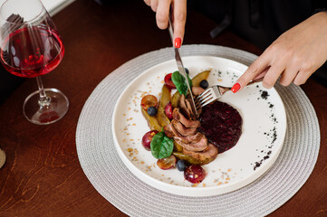 Female eating dish with duck and cranberry sauce at the restaurant