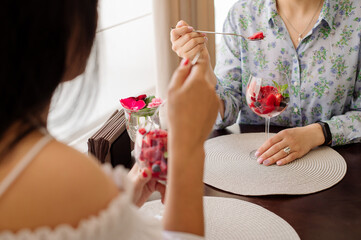 Female rastaurant client is eating a cold iced strawberry sorbet