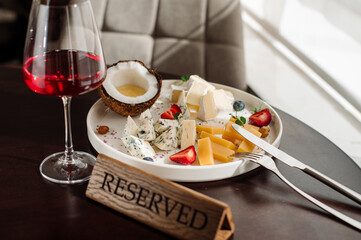 A dish with variety of cheese with honey and fruits on the table at the restaurant