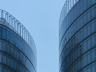 Close-up view of modern business towers with windows and a clear blue sky in the background