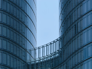 Obraz premium Close-up view of a modern business tower with windows and a clear blue sky in the background