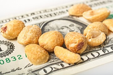 'Close up of peanuts partially covering  a U.S. one dollar bill'