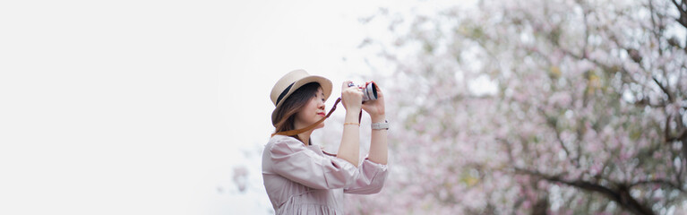 web banner asian woman photographer travel outdoor with pink flower in springtime season