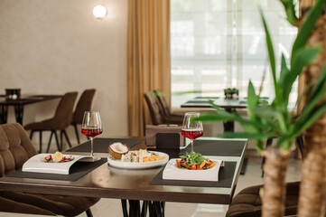 Served table with dishes and red wine in the restaurant