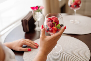 Female rastaurant client is eating a cold iced strawberry sorbet - obrazy, fototapety, plakaty