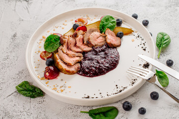 Dish of grilled duck medalions with cranberry sauce. Top view
