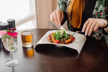 Female client of the rastaurant is eating a salad. Close up