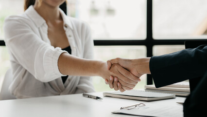 The job interviewer and the job applicant are holding hands after the job interview is finished. The concept of recruiting employees to work in the company, vacant positions.
