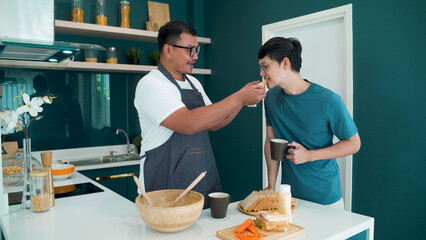 Two lovers cook together, and when they're done they both stand together for coffee and sandwiches, cute in the kitchen, and the friendship of LGBTQ couples.