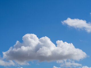Naklejka na ściany i meble A soft fluffy white cloud in an azure-blue sky. Beautiful cloudy sky