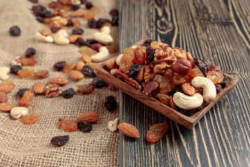 Mix of nuts and raisins on a wooden table.