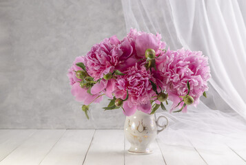 Bouquet of pink peonies in a vase on a wooden table. Gift Valentine's Day
