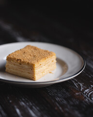 A piece of cake on a white plate. natural light. Food photography.