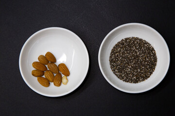 Healthy food in two round white porcelain bowls on a black background