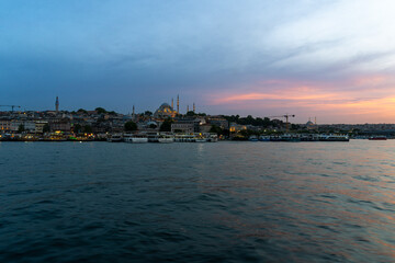 Obraz premium Sunset over the city of Istanbul, with a mosque in the photo, with the blue and orange sky, sailing on the Bosphorus