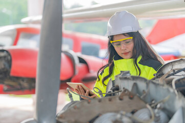 Technician fixing the engine of the airplane,Female aerospace engineering checking aircraft engines,Asian mechanic maintenance inspects plane engine