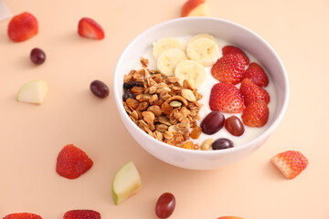 bowl of granola cereal with yogurt and berries isolated on eggnog color background