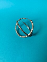 Round earrings on the blue background 