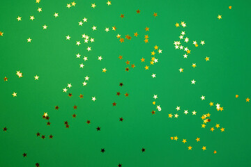 Gold sequins on a green background, new year concept