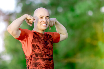 Young athletic man showing muscles outdoors