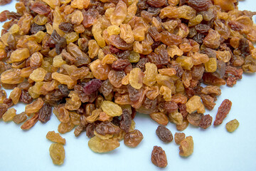 raisins of different varieties on a light blue background, culinary background