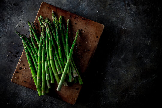 Fresh green asparagus on wooden cutting board.
Delicious green asparagus image.
