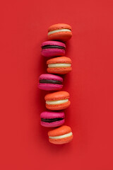 Tasty french macarons on a red background.