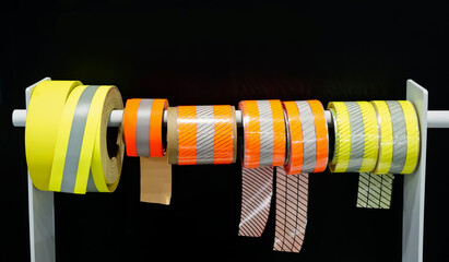 Obraz premium Reflective Adhesive Sticker for Safety in Rolls on a black background. 