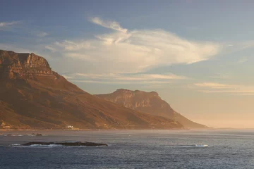 Fototapeten Seascape, landscape, scenic view of Hout Bay in Cape Town, South Africa at sunset. Blue ocean and sea with mountains in the evening with copyspace. Travel abroad and overseas for holiday and vacation © SteenoWac/peopleimages.com