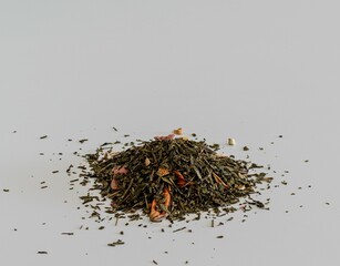 Dry leaf tea with pieces of berries and fruits on a white background