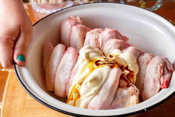 Chicken wings in a dish with mayonnaise and soy sauce.