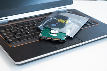 Hard disc is upgraded and placed in ESD packaging on a PC keyboard. The packaging protects...