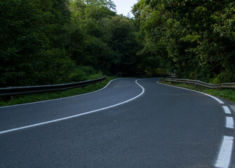 Fototapeta premium mountain road with new asphalt crossing through forest. rural vacation trip.