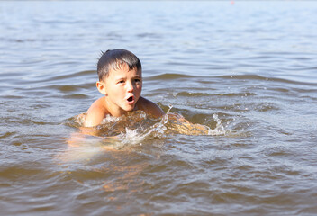 Fototapeta na wymiar a boy swims in the water