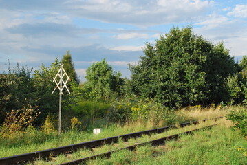 railroad track, scrub and railroad sign