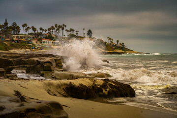 2022-07-04 WAVES CRASHING ON THE SHORELINE AT THE WINDANSEA BEACH IN LA JOLLA CALIFORNIA WITH PALM TREES AND A NICE SKY