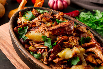 Fried chanterelles with mushrooms, in a clay pan, close-up, top view, selective focus,