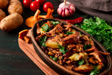 Fried chanterelles with mushrooms, in a clay pan, close-up, top view, selective focus,