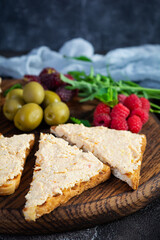 Toasts with chicken rillettes, olives and berrys. Sandwich snack with chicken pate