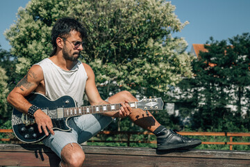 hipster guitarist on the street playing electric guitar