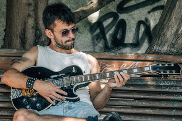 hipster guitarist on the street playing electric guitar