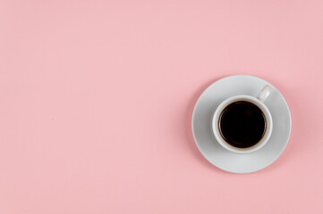 Espresso coffee against a pink background. White cup and saucer. Hot drink. Copy space for text and design elements.