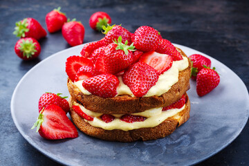 Traditional roasted Italian panettone tiramisu with vanilla custard curd and strawberries served as close-up in a design plate