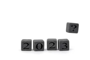 Happy New Year 2023. the concept of a New Year's background, stone cubes with the inscription 2023 and a cube in flight with a question mark