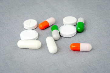 Medication: capsules and pills on a gray background. Medical concept. Close-up