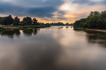 Beautiful cloudy sunrise at summer over long silent Odra river - obrazy, fototapety, plakaty